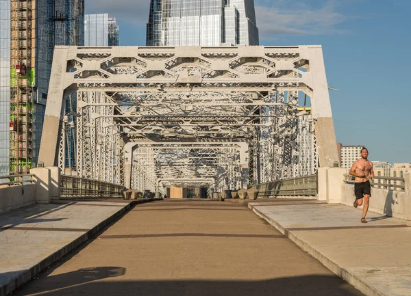 Runner on John Seigenthaler pedestrian bridge or Shelby street crossing at sunrise in Nashville — Stock Photo, Image