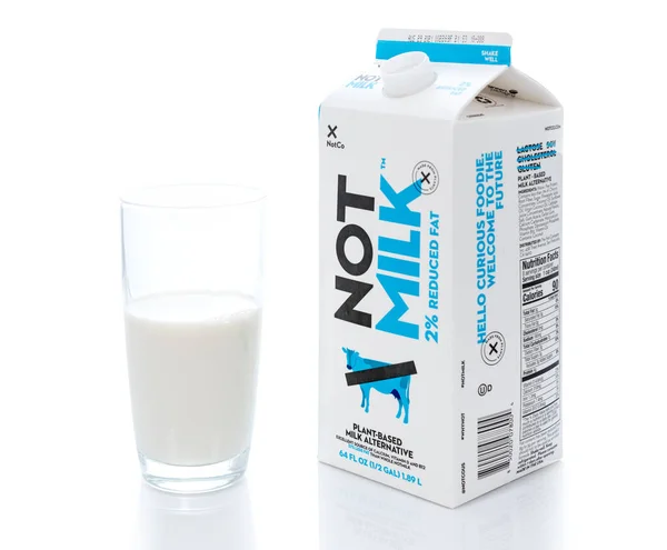 Carton of NotMilk milk alternative by glass tumbler — Stock Photo, Image