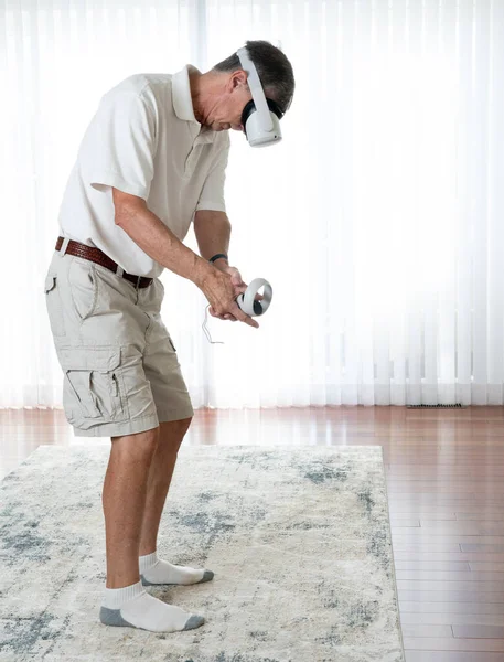 Homme adulte âgé jouant à un jeu de golf sur un casque VR moderne — Photo