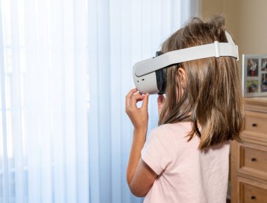 Modern bir VR kulaklıkla uygulamayı izleyen genç bir kız.