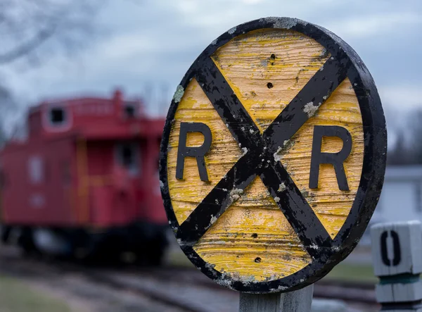 Velha ferrovia de madeira RR sinal com caboose — Fotografia de Stock