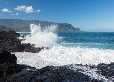 Waves hit rocks at Queens Bath Kauai clipart