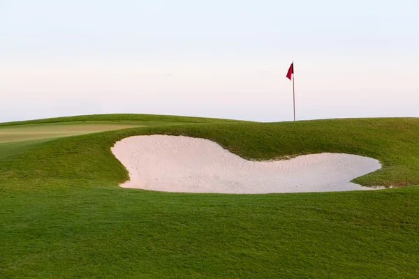 Vlajky a písek zelený bunkru přední golf — Stock fotografie