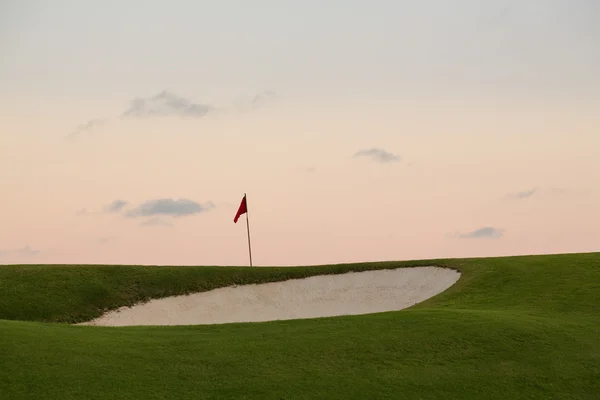 Sand bunker in front of golf green and flag — Stock Photo, Image