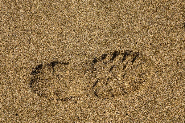 单右鞋打印在沙子 — 图库照片