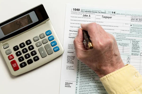 Pluma y calculadora en 2014 formulario 1040 — Foto de Stock