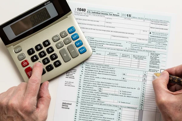 Pen and calculator on 2015 form 1040 — Stock Photo, Image