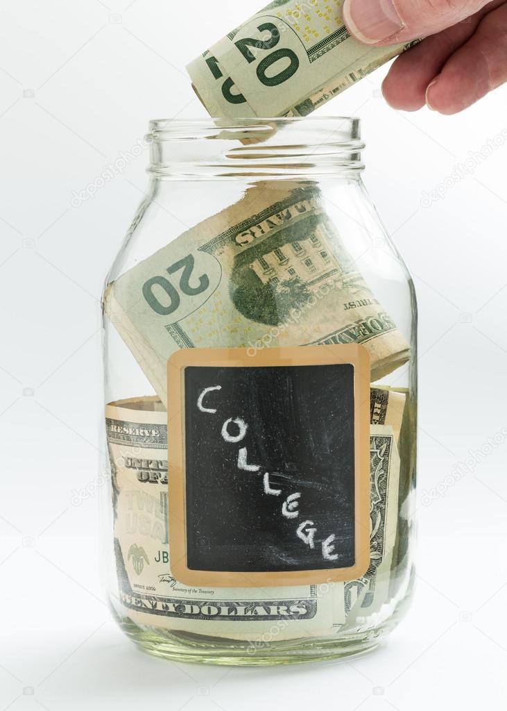 Hand inserting money into saving jar or bank