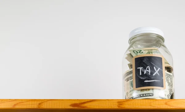 Single glass jar on wooden shelf for saving money — Stock Photo, Image