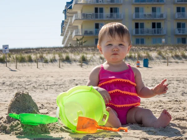 Dziecko dziewczynka degustacja piasku na plaży — Zdjęcie stockowe