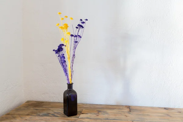 Flores secas em vaso de garrafa azul em madeira — Fotografia de Stock