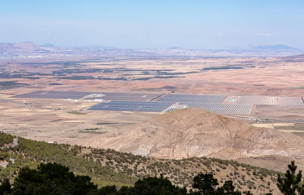 Paneles solares en el sol bajo las montañas — Foto de Stock