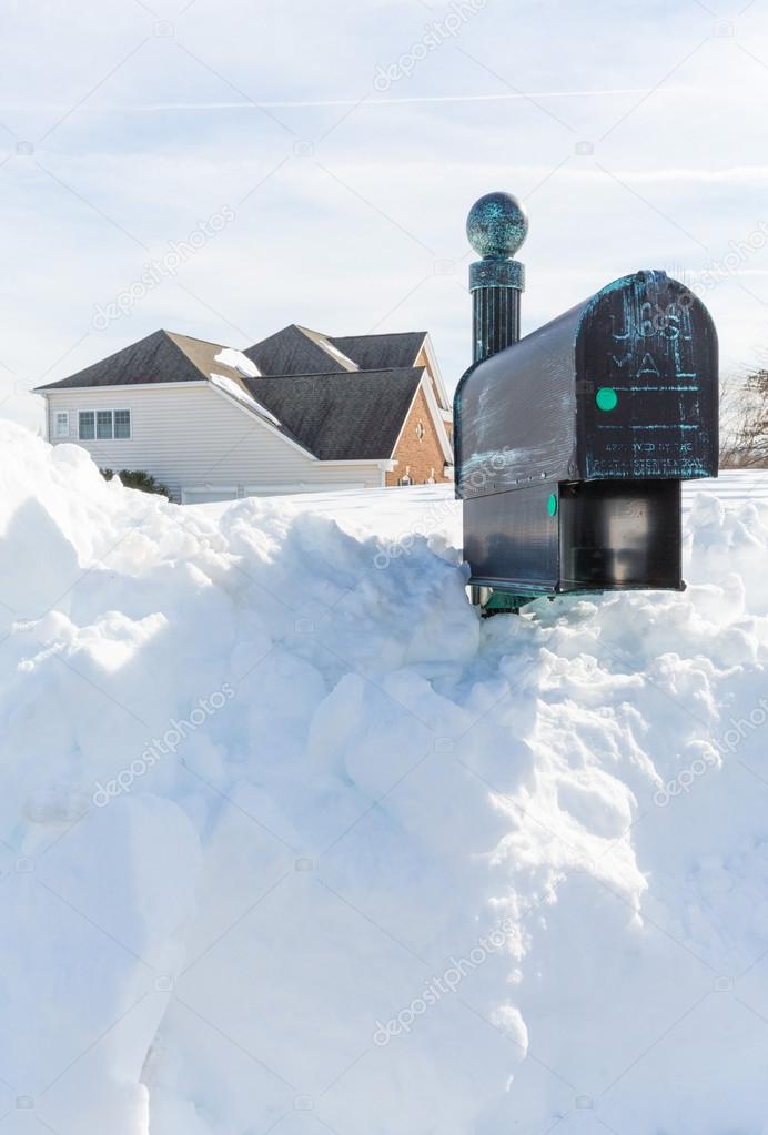 Deep drifts bury mailbox of modern home