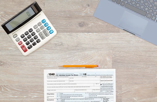 Laptop and calculator on 2015 IRS form 1040 — Stock Photo, Image