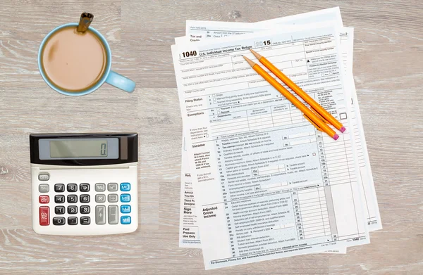 Coffee and calculator on 2014 IRS form 1040 — Stock Photo, Image