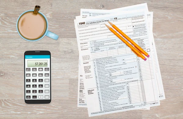 Coffee and calculator on 2015 IRS form 1040 — Stock Photo, Image