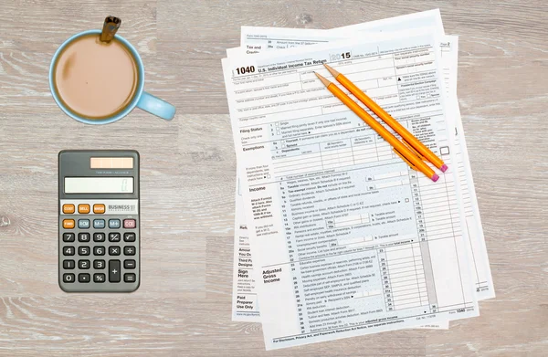 Coffee and calculator on 2014 IRS form 1040 — Stock Photo, Image