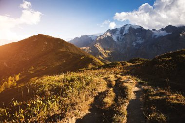 Güneşli kirişlerdeki dağlık çayırlar. Zemo Svaneti, Gürcistan ülkesi, Avrupa. Kafkasya sırtı. Vahşi bölgenin manzaralı görüntüsü. Toprağın güzelliğini keşfedin. Macera ve yaşam tarzı yürüyüş konsepti