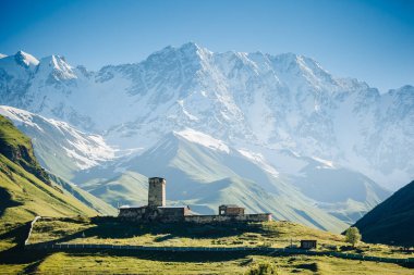 Ushguli köyü manzarası ve parlayan büyük tepeler. Lamaria Church Jgrag, Yukarı Svaneti, Gürcistan, Avrupa. Kafkasya Tepesi. Vahşi bölgenin manzaralı görüntüsü. Toprağın güzelliğini keşfedin.