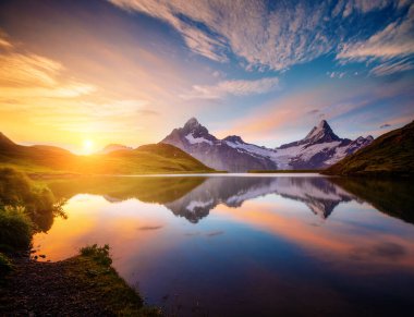 Alp Gölü Bachalpsee 'nin şafak vakti muhteşem manzarası. İsviçre Alpleri, ünlü Grindelwald tatil beldesi, Bernese, Avrupa. Çekici duvar kağıtları. Seyahat güzergahı. Toprağın güzelliğini keşfedin.