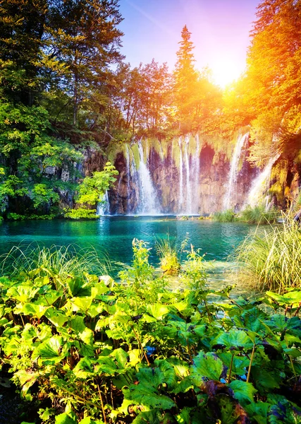 Waterfall with turquoise water and sunny beams — Stock Photo, Image