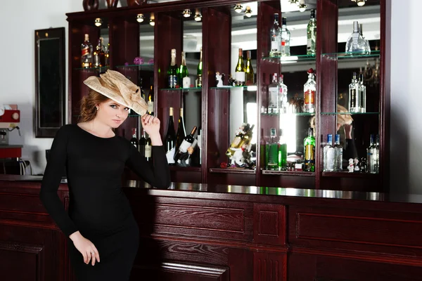 Vrouw staand in een luxe bar. — Stockfoto