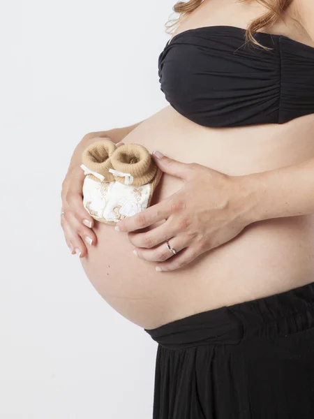 Mulher grávida segurando as mãos na bela barriga — Fotografia de Stock