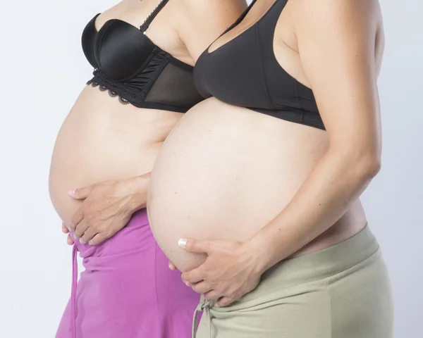 Zwangere vrouwen hand in haar hand op mooie buik — Stockfoto