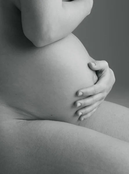 Беременная женщина держит руки на красивом животе — стоковое фото