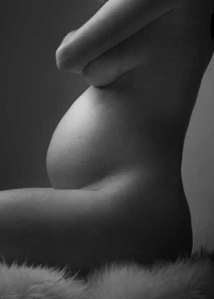 Mulher grávida segurando as mãos na bela barriga — Fotografia de Stock