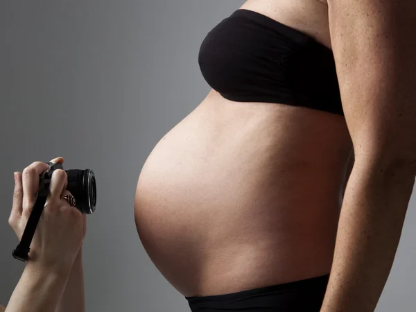 Barriga de uma mulher grávida a ser fotografada — Fotografia de Stock