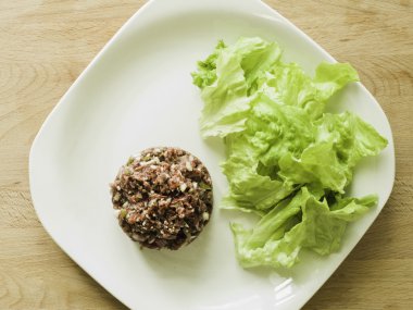 bir kase içinde Steak tartare malzemeyi karıştırma