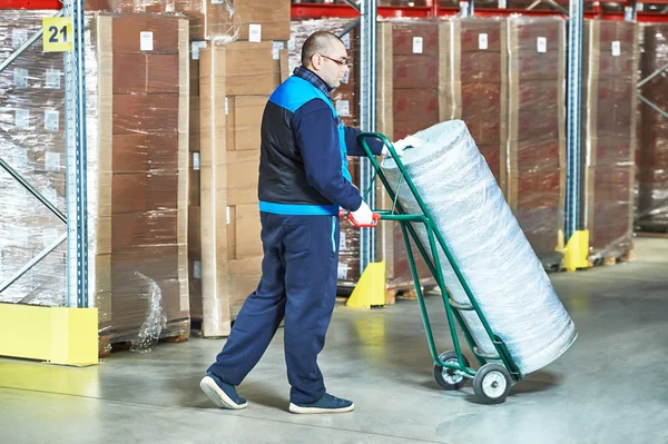 Worker with  delivery cart in warehouse — Stock Photo, Image