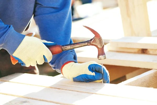 Worker hammering nail — Stock Photo, Image