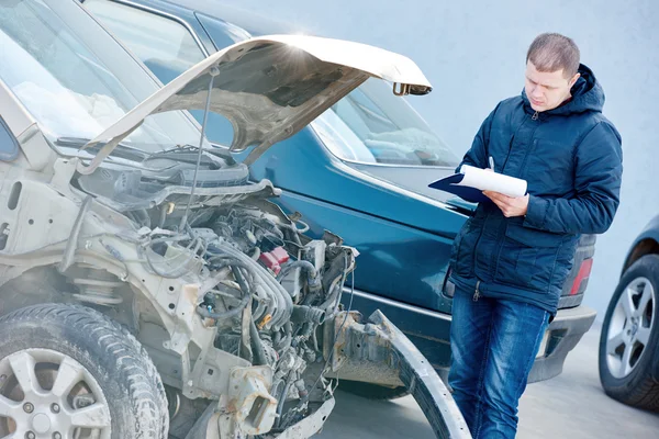 Insurance agent recording car damage on claim form — Stock Photo, Image