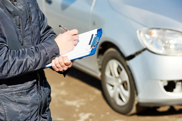 Insurance agent recording car damage on claim form — Stock Photo, Image