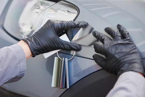 Colourist man selecting color of car with paint matching samples — Stock Photo, Image