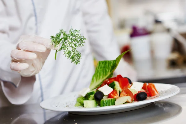 Cuisinier décorant à la main la cuisine de salade préparée — Photo