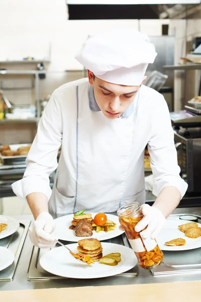 Male cook chef decorating food on the plate — Stock Photo, Image