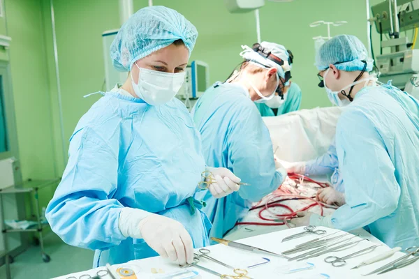 Cirujanos en el trabajo. médicos femeninos que operan en el hospital de cirugía infantil — Foto de Stock