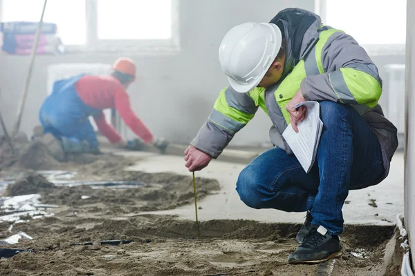 Foreman builder inspecting concrete construction work in apartment — Stock Photo, Image