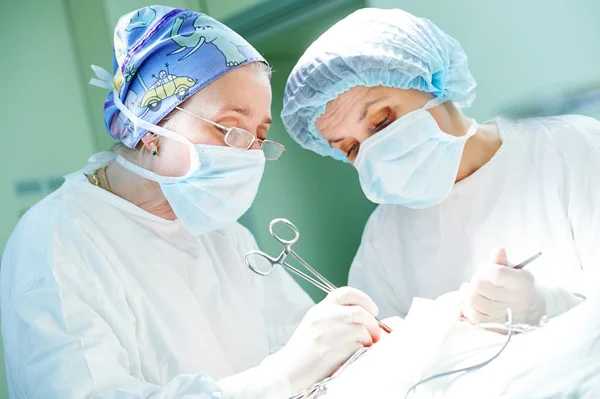 Cirujanos en el trabajo. médicos femeninos que operan en el hospital de cirugía infantil — Foto de Stock