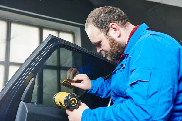 Teñido de coche. Técnico mecánico de automóviles aplicando lámina — Foto de Stock