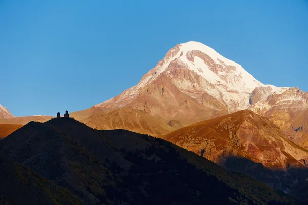 Kazbek Monte panorama con la iglesia cristiana Gergeti —  Fotos de Stock