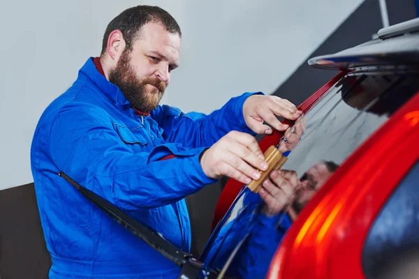 Teñido de coche. Técnico mecánico de automóviles aplicando lámina — Foto de Stock