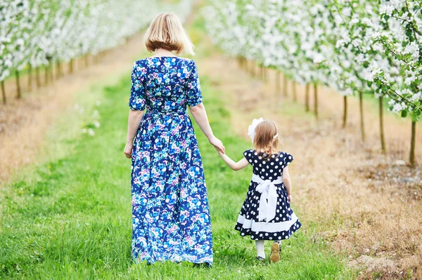 Anne ve kız bahar çiçek açan bahçesinde — Stok fotoğraf