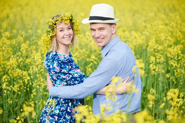 Feliz jovem casal adulto no campo amarelo primavera — Fotografia de Stock