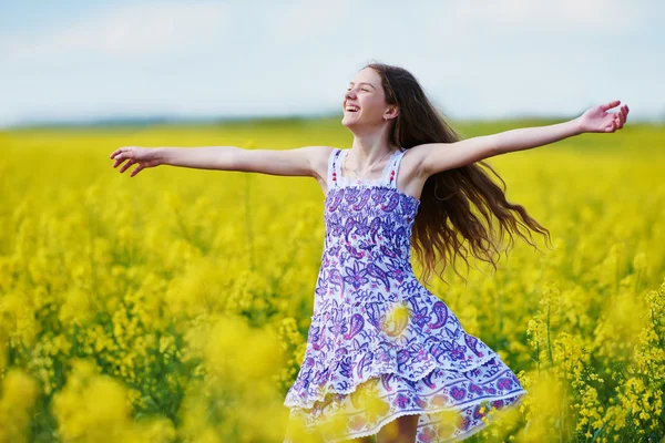 Joyful girl with flower garland at yellow rape seed meadow — Stock Photo, Image