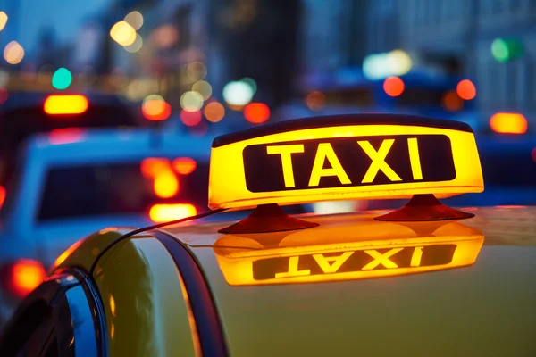 Cartel de taxi en el coche por la noche en la calle de la ciudad — Foto de Stock