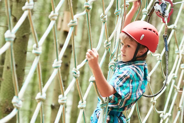 Ragazzo all'attività di arrampicata nel parco forestale ad alto filo — Foto Stock